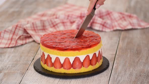 Cutting Fresh Baked Cake with Strawberry Jelly Topping