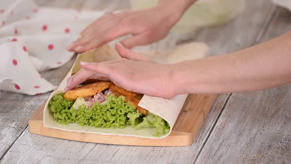 Woman is Cooking Pita Bread Roll with Chicken and Vegetables