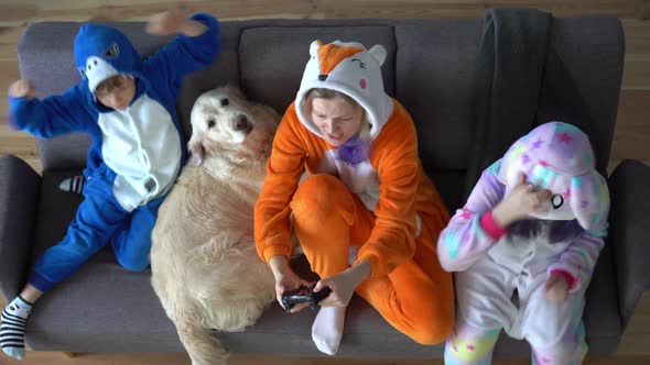 Happy Family in Kigurumi Playing a Game Console on the TV in the Living Room at Home - Top View