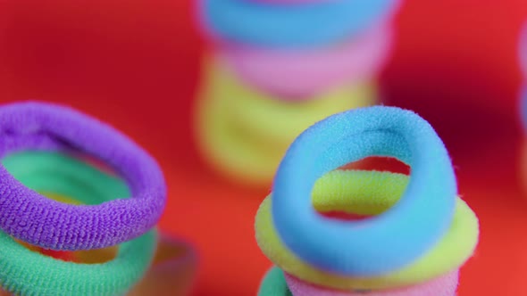 Vibrant Colors Rotating Close Up Rubber Bands on the Red Background alt