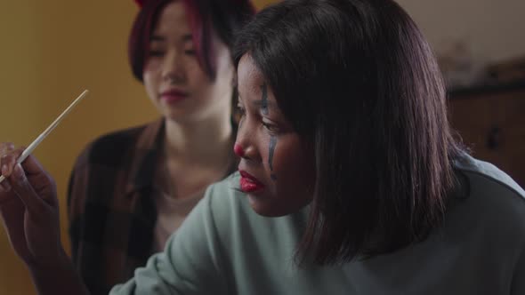 A Young Lady is Drawing Her Friend a Greasepaint alt