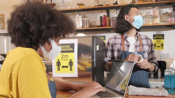 Two barista partners wait for customers order in new normal lifestyle service. alt