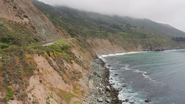 Aerial Drone Shot Ascending to Reveal a Road on Steep Coastline (Big Sur, Pacific Coast Highway, CA)