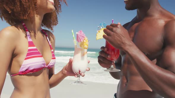African american couple drinking cocktail seaside alt