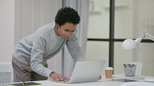 Young African Woman Standing and Using Laptop  alt