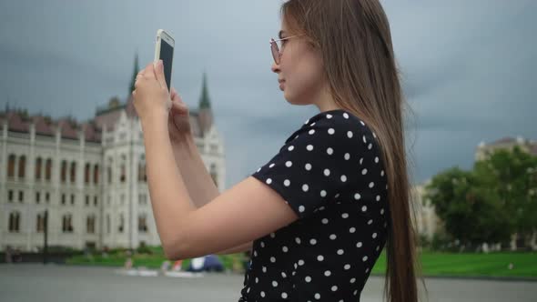 Girl Taking Smartphone Pictures of Hungarian Parliament Building in Budapest alt