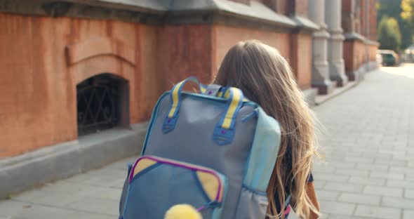 Follow Up Shot of Little Girl Running Into School Building alt
