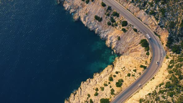 View of the Country Road with Driving Cars and Blue Sea From Above alt