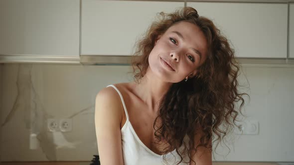 The Young Woman is Turning Her Head and Looking at the Camera alt