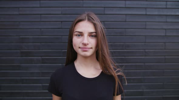 Charming Young Woman with a Magnificent Big Blue Eyes, She Turns To Camera and Smiles. alt