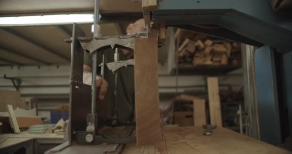 Carpenter pulls and slides wood on a saw