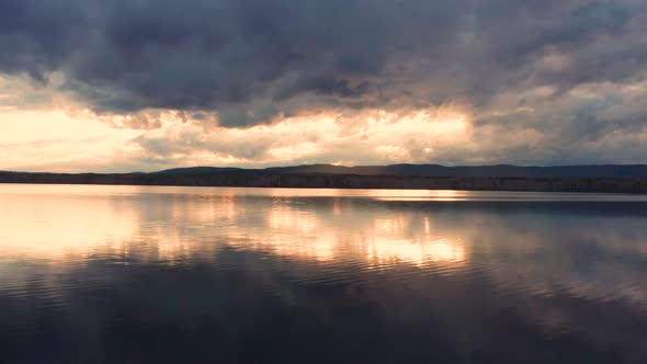 Aerial View of the Natural Landscape Forest on the Lake Shore at Sunset alt
