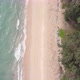 Top down aerial view and fly over beach near resort or village with green color of water - VideoHive Item for Sale