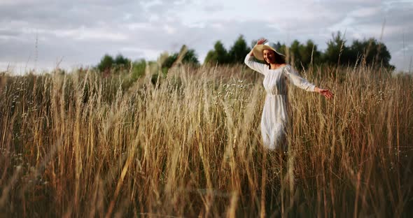 Happy Woman Running on Field Sunset