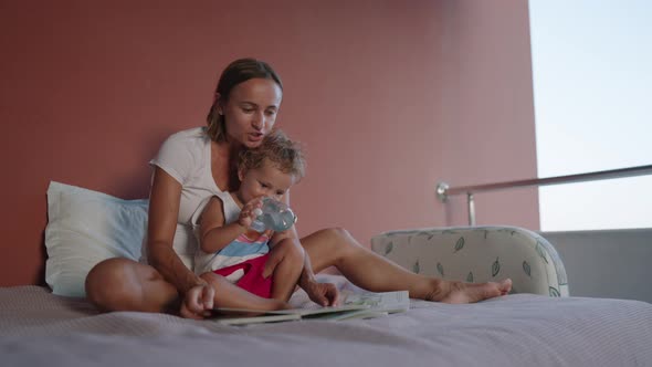 Happy Family Mother and Son Read a Book in the Evening at Home alt