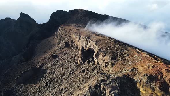 Drone footage of clouds over the crest of the Piton des Neiges at the Reunion island. alt
