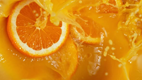 Super Slow Motion Shot of Orange Slices Splashing To Orange Juice at 1000Fps. alt
