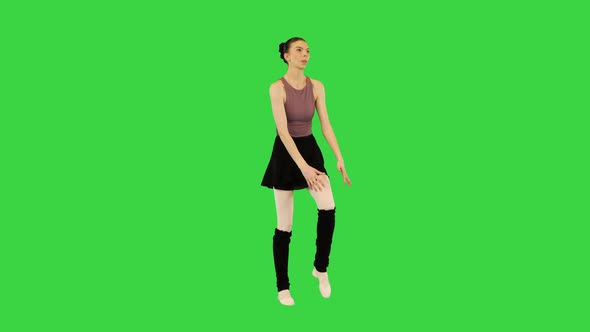 Young Ballerina in Training Clothes Makes a Warmup on a Green Screen Chroma Key