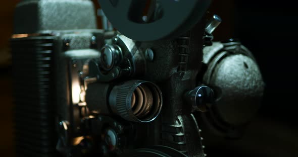 Moody close up of an old 8mm projector, shallow depth of field and high contrast. alt