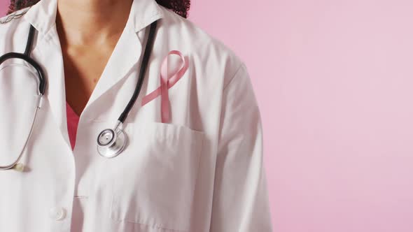 Video of biracial female doctor with pink breast cancer ribbon alt