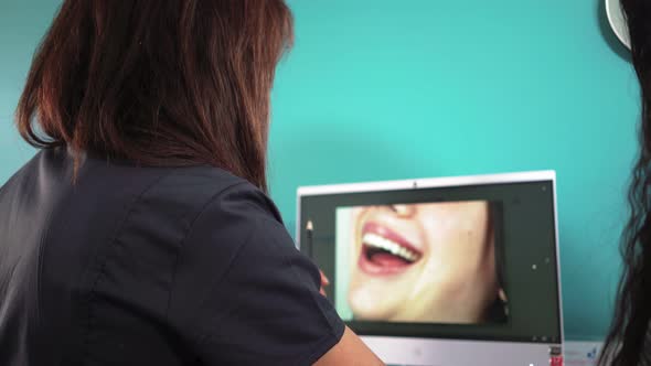 Woman Professional Dentist Discusses Treatment Plan with Patient at Computer alt