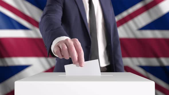 Voting. Man Putting a Ballot into a Voting Box with British Flag on Background.