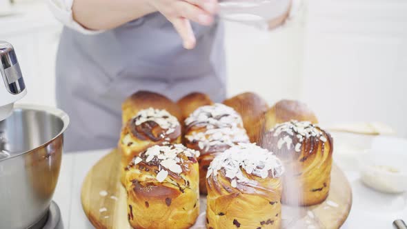 a Female Cook Sprinkles with Powdered Sugar and Almonds a Kraffin Easter Cake alt