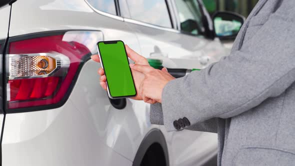 Woman Uses a Mobile Application in a Smartphone To Pay for Refueling a Car. Smartphone with a Green alt