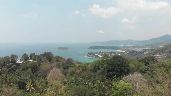 Fly-forward overtaking reveal of Karon Beach landscape overlooking the Andaman Sea in Phuket alt