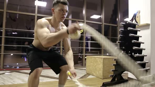 Session battle ropes. an athlete who develops a gym in a functional training alt