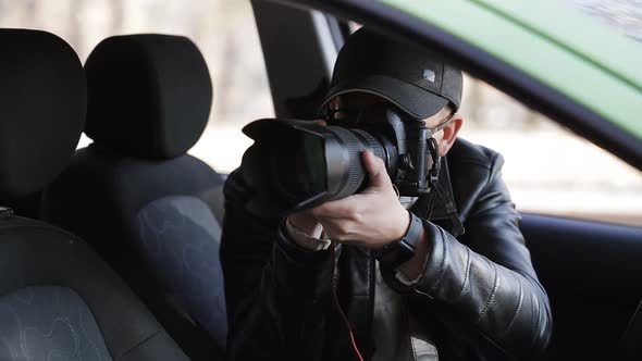 Private Detective Man Sitting Inside Car and Photographing with Dslr Camera alt