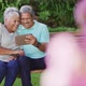 Video of happy biracial senior couple using tablet in garden