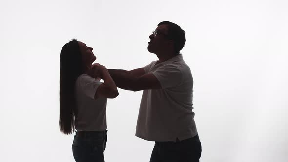 Silhouette of Man From Rage and Anger Strangling Woman White Background in Studio Side View alt