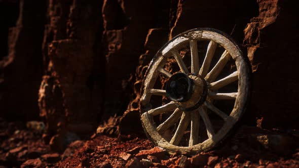Old Wooden Cart Wheel on Stone Rocks alt