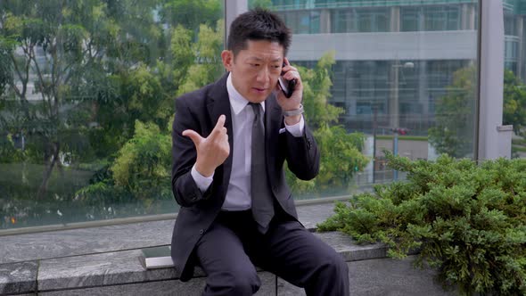 Japanese businessman talking on a cell phone alt
