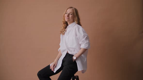 Elegant Professional Model in the White Shirt Posing to a Camera in the Studio