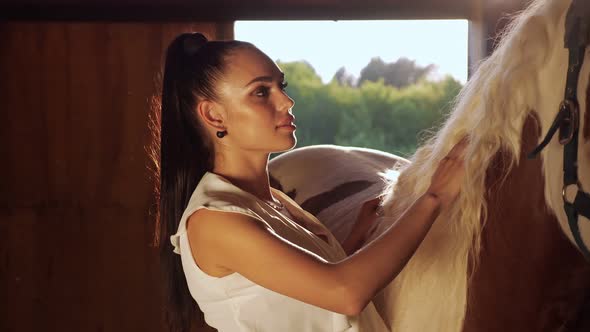 Young Woman Brunette with Long Hair in Ponytail Pets Horse alt