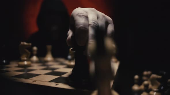 Unrecognizable Man in Hoodie Moving White Queen Defeating White King of Opponent During Chess Game alt