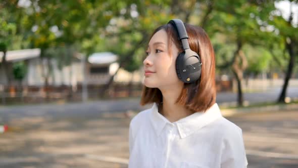 Cute girl listening to music in the park