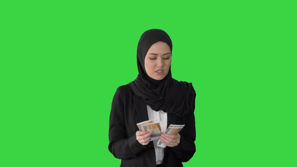 Pretty Woman in Hijab Walking and Counting Money on a Green Screen, Chroma Key alt