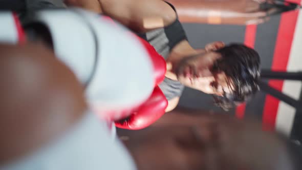 Vertical shot of Active Fitness trainer teach and motivate young Caucasian sportsman doing boxing. alt