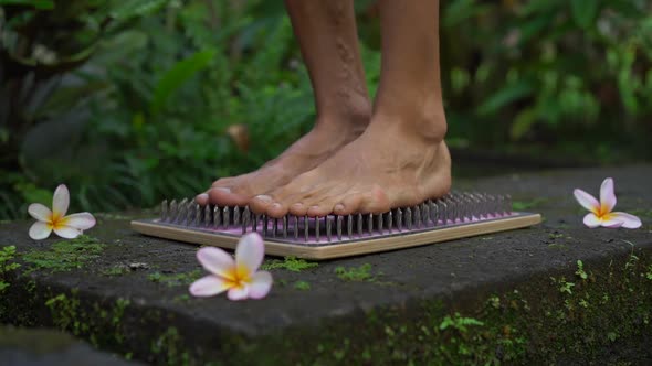 Slowmotion Shot of a Young Man That Using a Sadhu Board or a Nail Board in a Tropical Surrounding alt