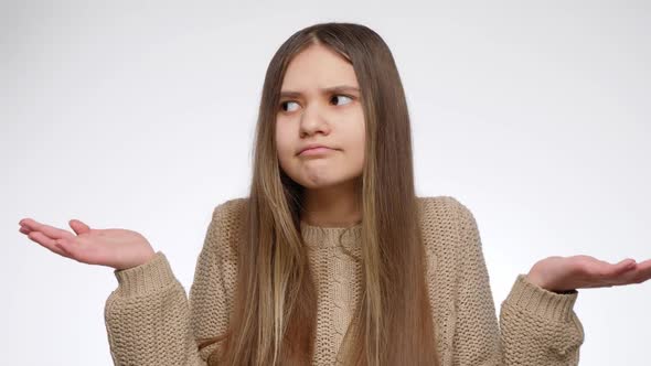 Portrait of Doubtful Girl Showing Confusion Gesture with Hands alt