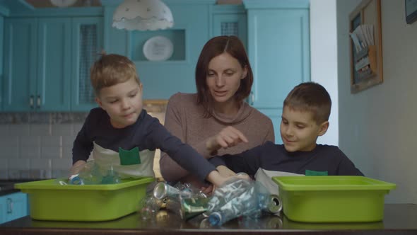 Family sorting home garbage for recycling plastic and tin  alt