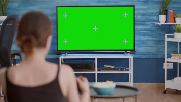 Over Shoulder View of Young Woman Playing Console Video Games with Wireless Controller on Green alt