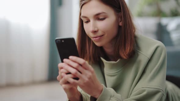 Woman Using Smartphone at Home alt