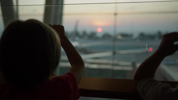 Child Standing Near the Window at the Airport alt