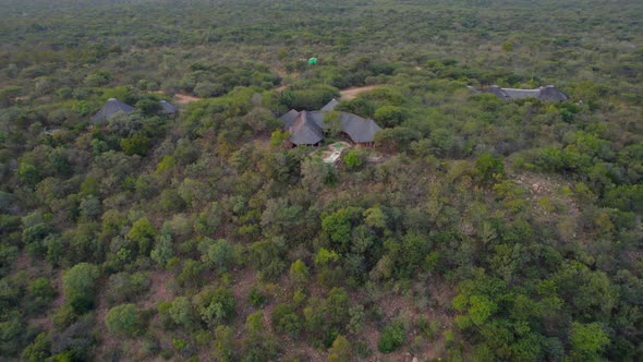 aerial shot over african lodges into primary savannah landscape alt
