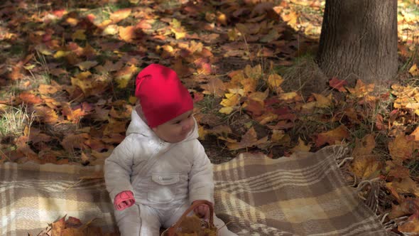 Authentic Little Cute Happy Chubby Caucasian Infant Baby Girl 68 Month in Red Hat Sitting on Plaid
