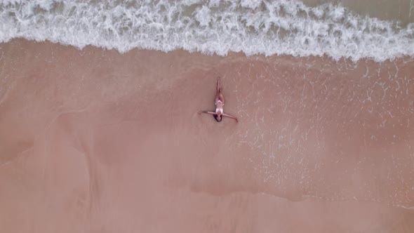 Woman In Bikini Lying In Shallow Tide On Nacpan Beach alt